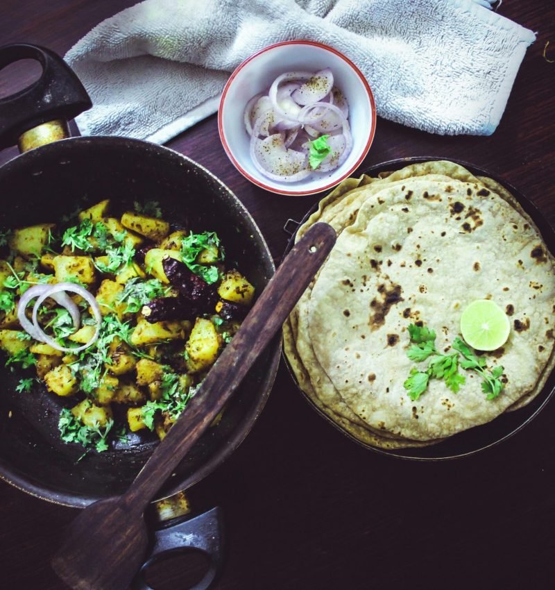 Bangalore-style home-cooked meal featuring roti, aloo fry, and fresh onions.